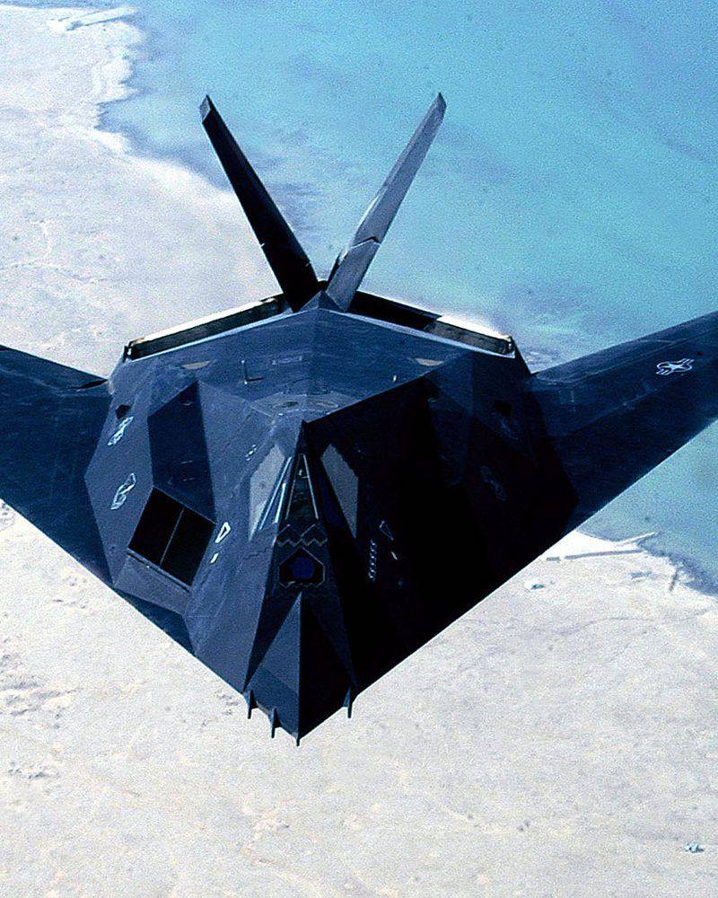 An F-117 Nighthawk stealth fighter flying over the desert