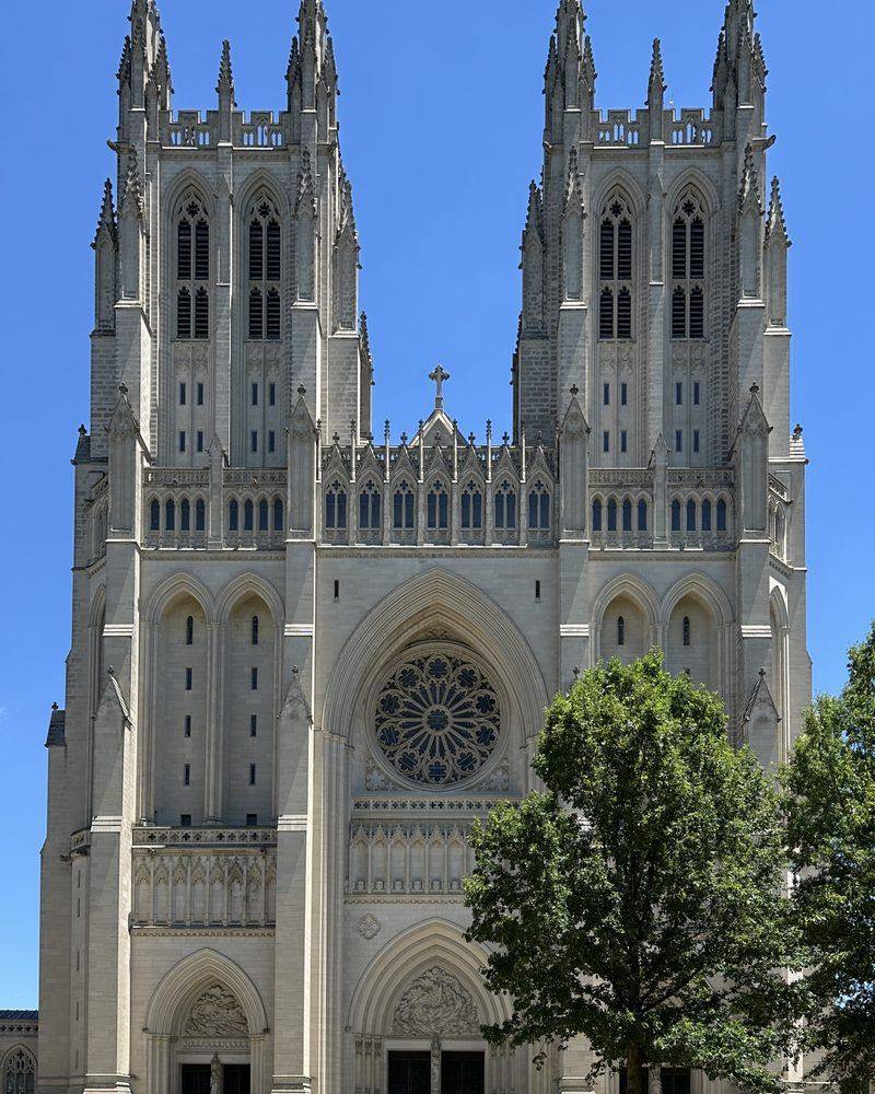 The twin-towered west front of Washington National Cathedral against a blue sky